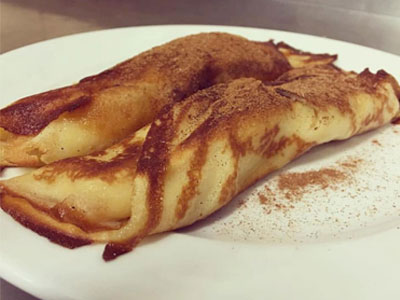 Filloas rellenas de crema flameadas o regadas con chocolate caliente