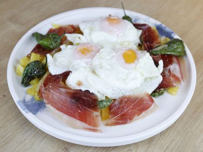 Bandeja de huevos rotos con jamón y pimientos de Padrón