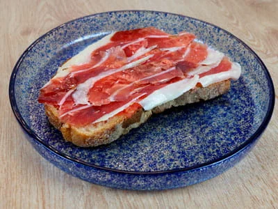 Jamón ibérico sobre cama de tumaca