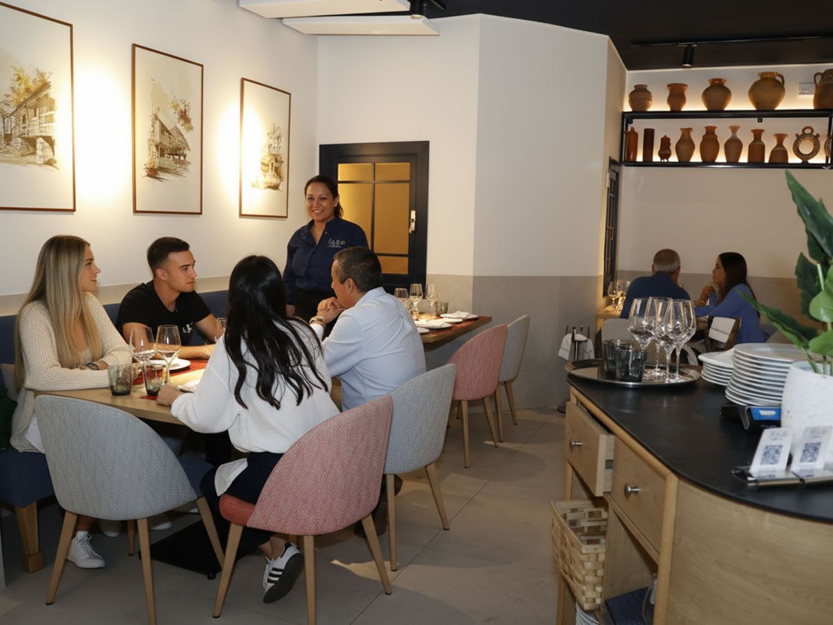 Comedor de Flor de Galicia, restaurante gallego en el Barrio de Salamanca, con mesas ocupadas y cerámica gallega al fondo