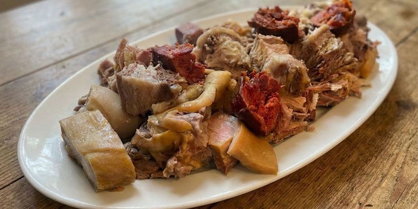 Cocido gallego tradicional servido por fuentes para compartir