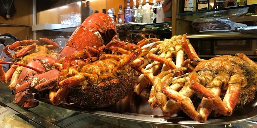 Centollo y nécoras cocidos expuestos en una vitrina de marisco
