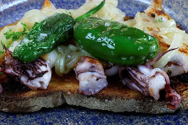 Tosta de chipirón con cebolla y pimiento del menú de cena de tapas en Madrid